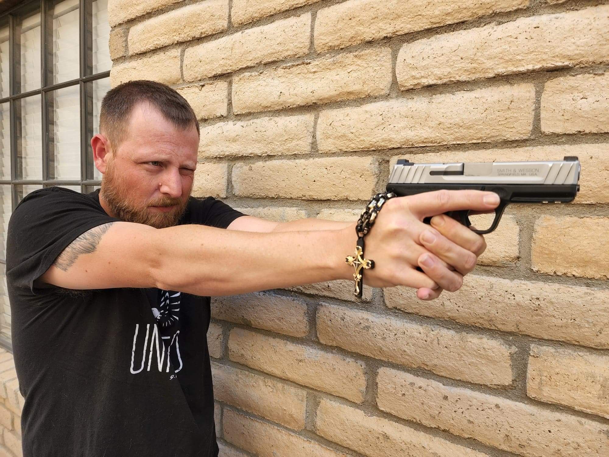 Man Holding a Pistol and Chained Cross